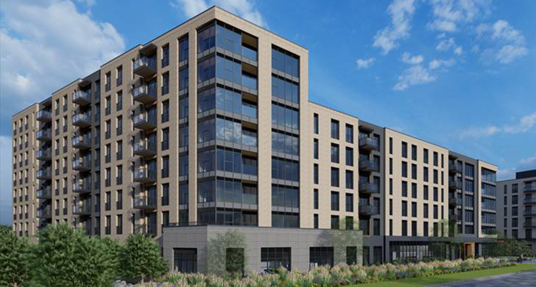 A modern apartment building in front of a blue sunny sky.